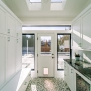 Kitchen with white cabinets and skylight, creating a bright and airy space.