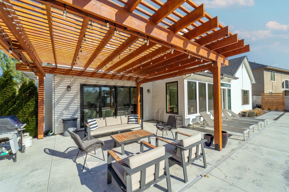 A serene patio with a pergola and comfortable chairs, providing a perfect spot for relaxation and outdoor gatherings.