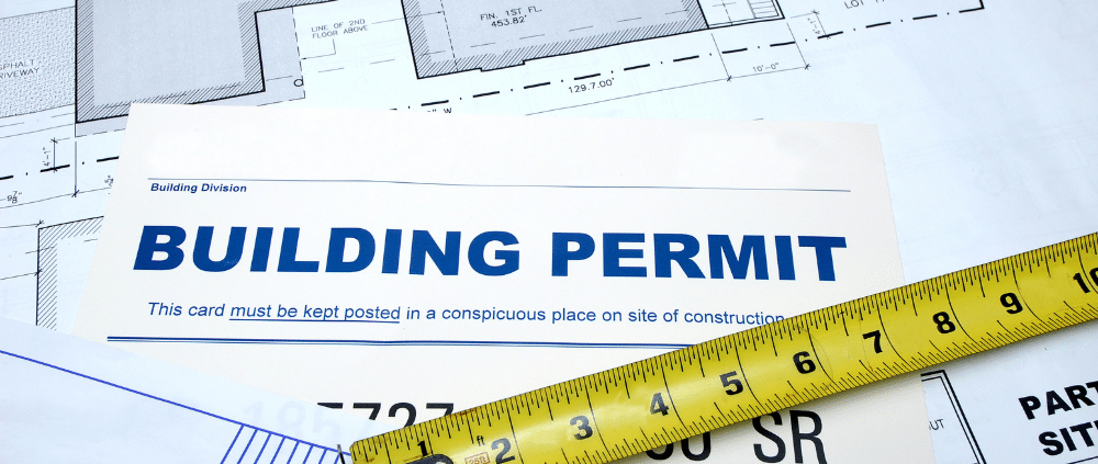 A construction plan with a building permit laying on a table, symbolizing progress in construction projects in Boise.