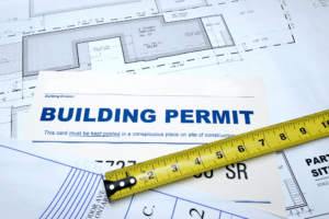 A construction plan with a building permit laying on a table, symbolizing progress in construction projects in Boise.